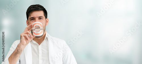 Young male dentist working in dental clinic. Dentistry care and medical service concept. photo