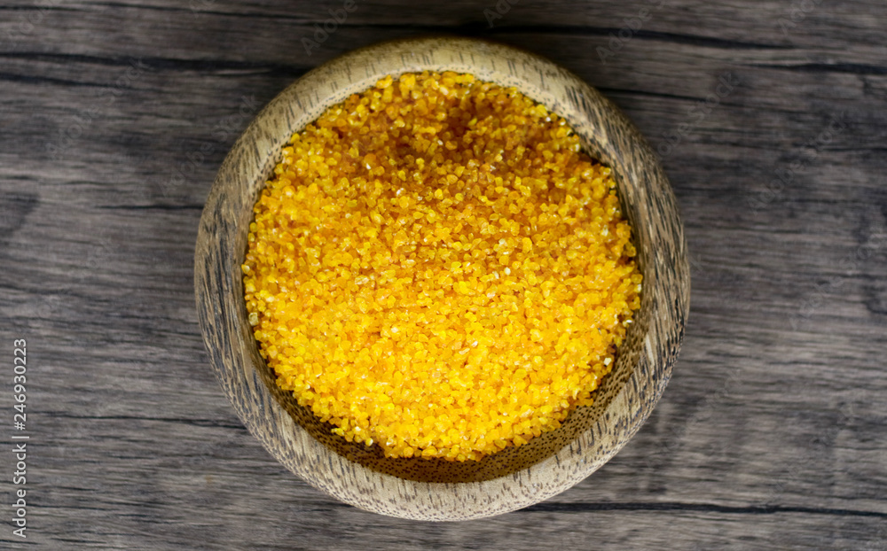 Yellow corn grits on wood background. Yellow corn grits on wood background.