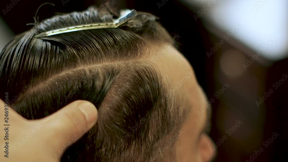 Hands of barber cut hair. Comb and scissors. Basic barbering techniques