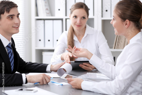 Group of business people at meeting on the background of office. Focus at a beautiful brunette woman