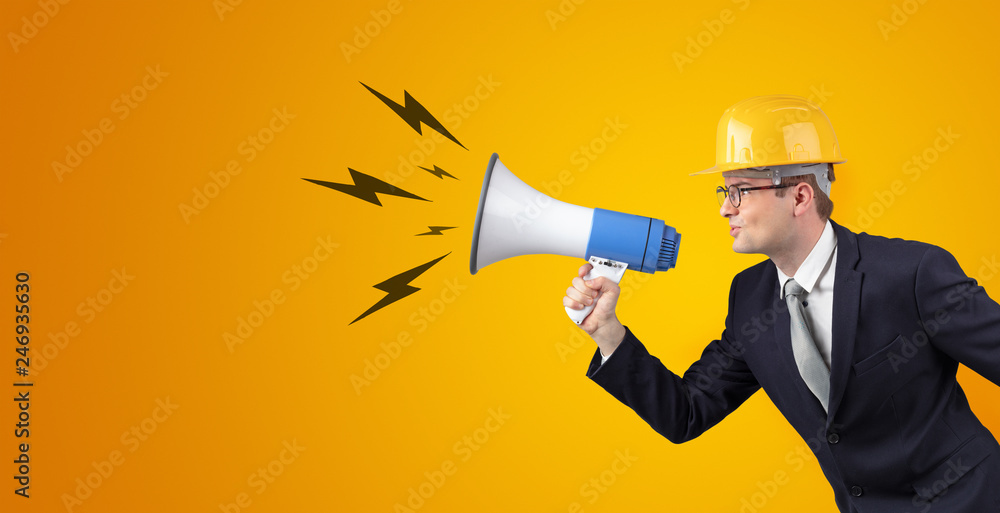 Fototapeta premium Young architect constructor yelling with megaphone and copyspace
