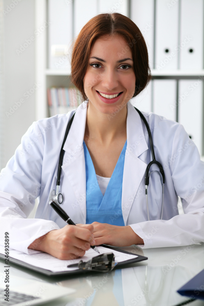 Doctor woman at work. Physician filling up medical history records form at the desk. Medicine, healthcare concept Doctor woman at work. Physician filling up medical history records form at the desk. Medicine, healthcare concept