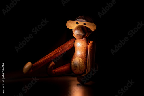 Photography A wooden toy figure of a monkey in the spotlight