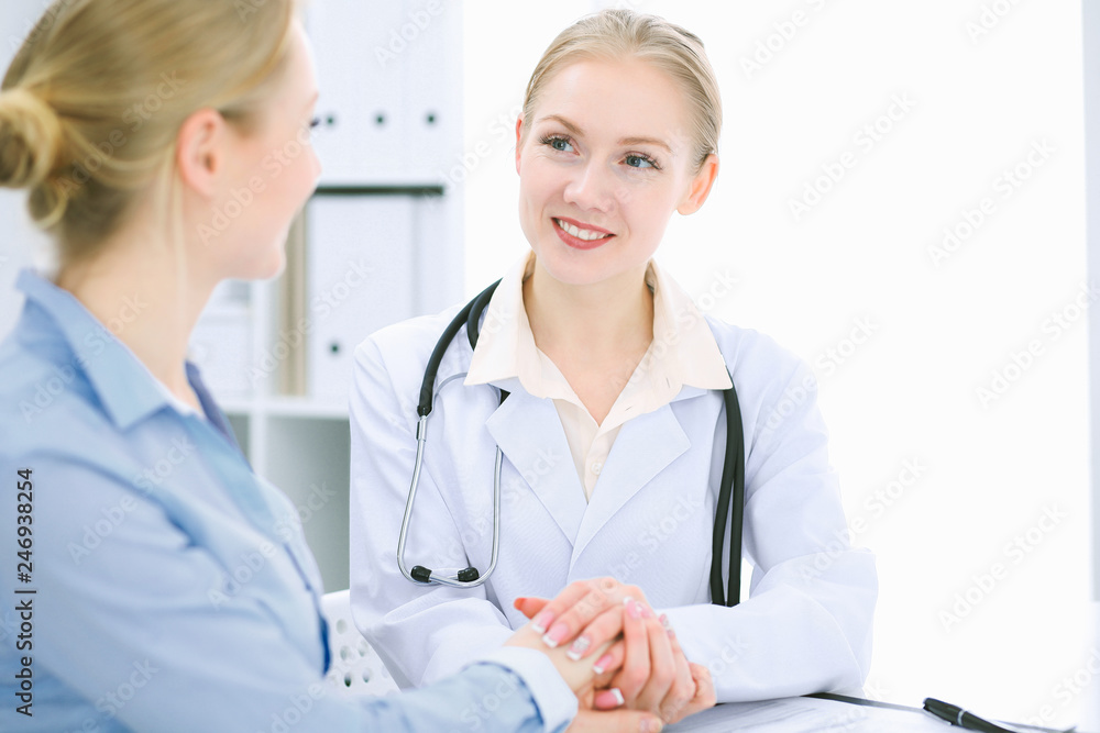 Doctor and patient talking in hospital office while sitting at the desk. Health care and client service in medicine Doctor and patient talking in hospital office while sitting at the desk. Health care and client service in medicine