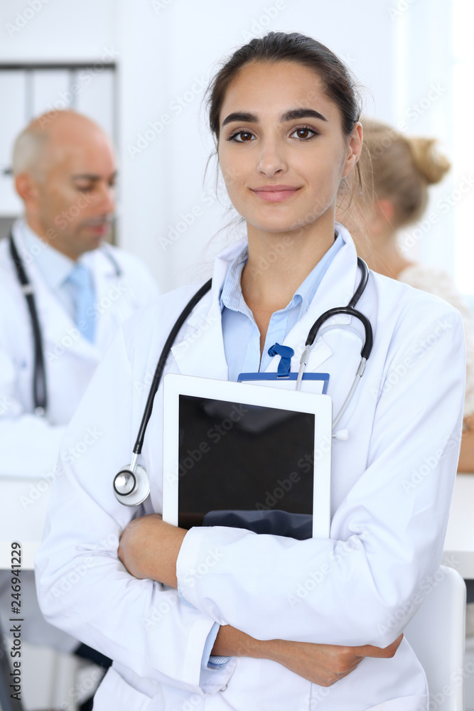 Portrait of young doctor woman using tablet pc in hospital. Hispanic or latin american staff in medicine. Patient service concept Portrait of young doctor woman using tablet pc in hospital. Hispanic or latin american staff in medicine. Patient service concept