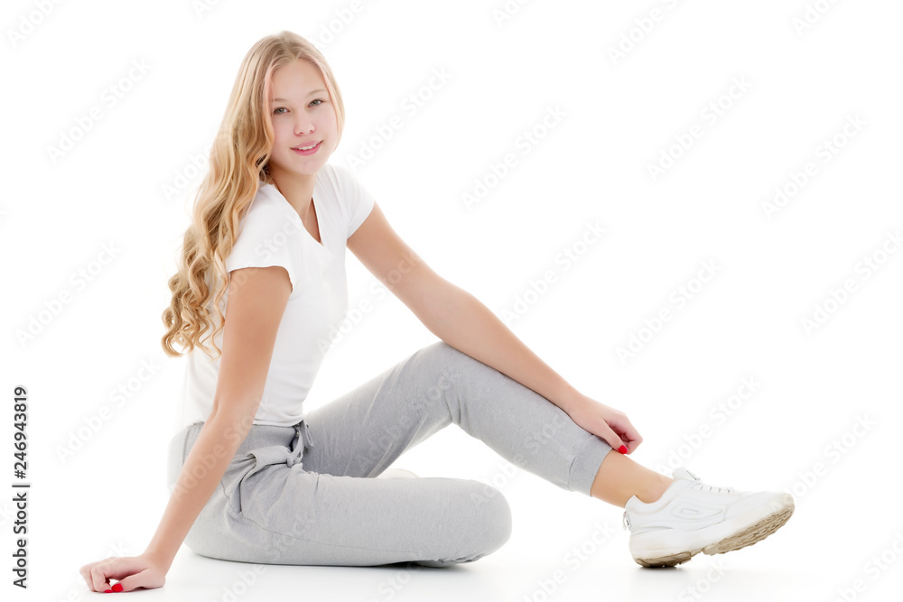 A teenage girl is sitting on the floor.