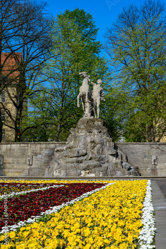 Blühende Frühlingsblumen vor dem Siegfriedbrunnen am Rüdesheimer Platz in Berlin-Wilmersdorf photo