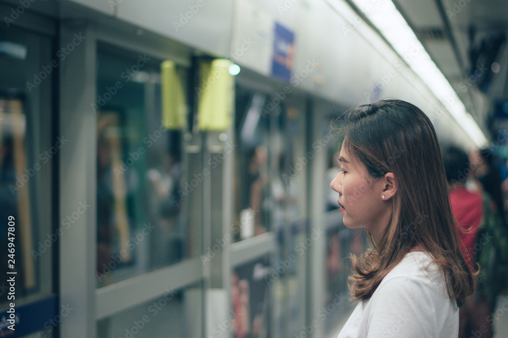 Woman waiting on the station platform at the airport link station.
