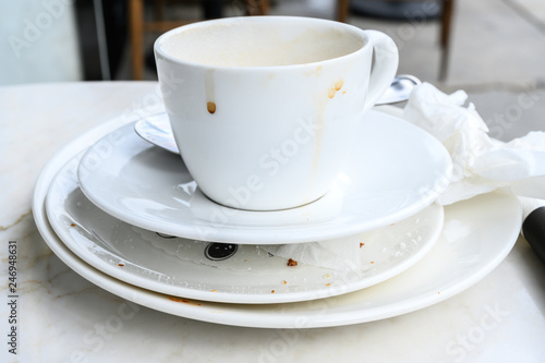 dirty coffee cup with plates on a pile 