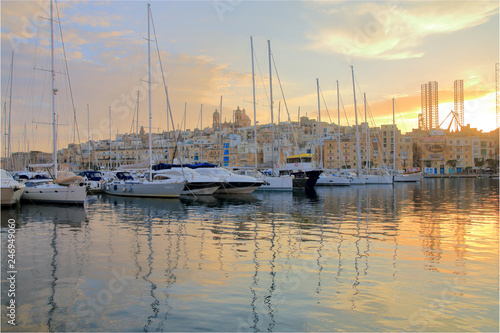 Yachts moored in the harbor of Malta in the rays of the setting sun. © scena15