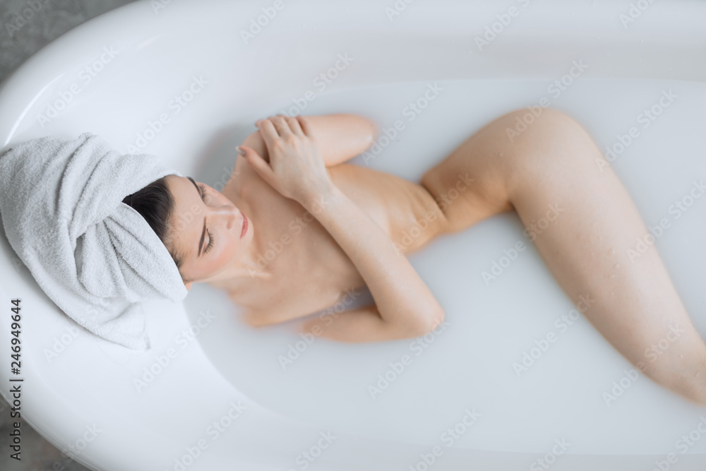 Sensual brunette business lady taking homemade skin care spa procedure in bathroom, enjoying with milky aromatic bath and rare moments of peace and quiet. Sensual brunette business lady taking homemade skin care spa procedure in bathroom, enjoying with milky aromatic bath and rare moments of peace and quiet.