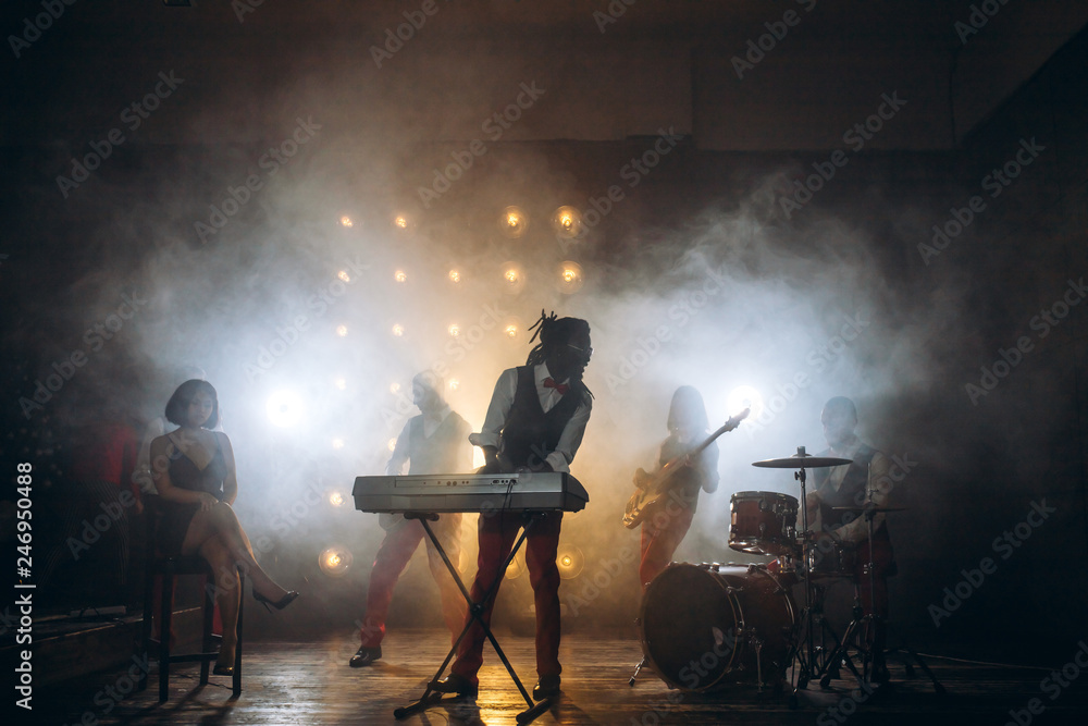 Fototapeta premium musical evening of popular band. agroup od mixed race young people taking part in the contest