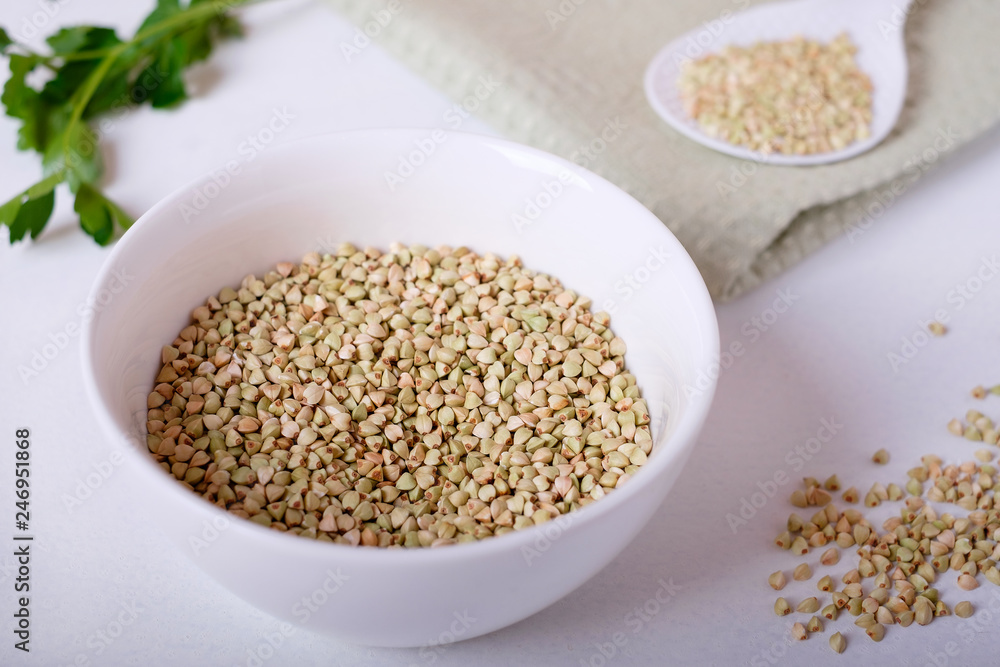 raw green buckwheat on a white background raw green buckwheat on a white background