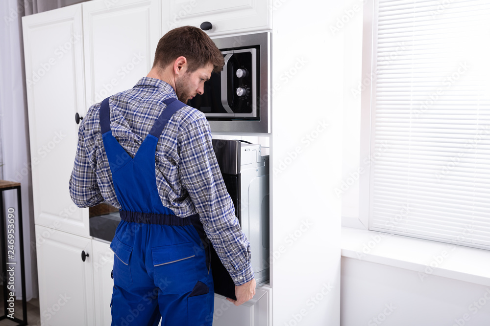 Technician In Overall Installing Oven Technician In Overall Installing Oven