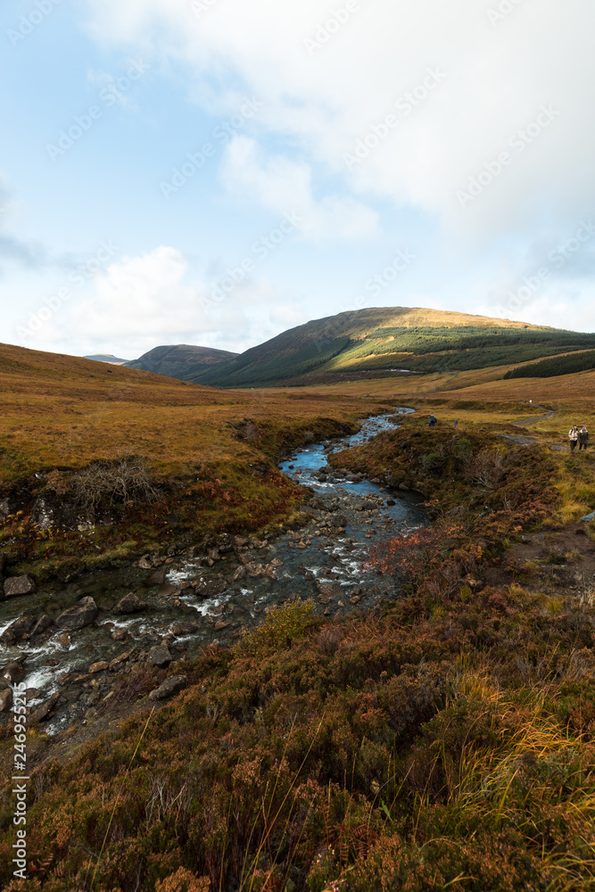 River flowing towards the valley at the Fairy Pools on Isle of Skye during a cloud-covered autumn day (Isle of Skye, Scotland, United Kingdom, Europe)