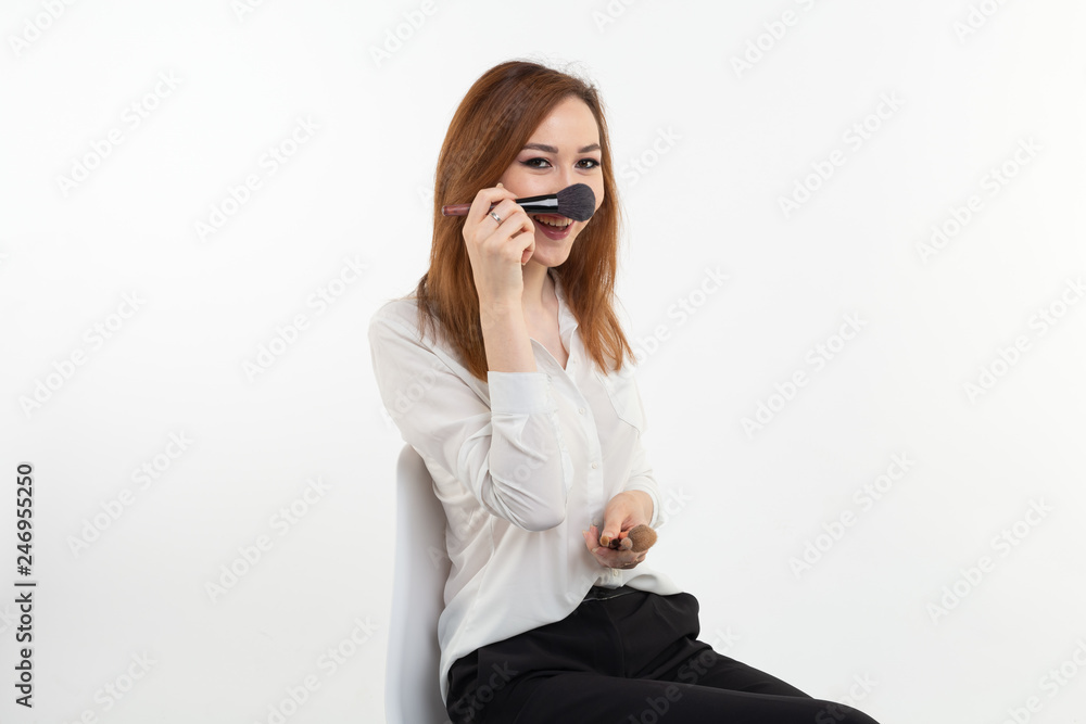 Fototapeta premium Funny visagist or korean make-up artist holding a makeup brushes on white background