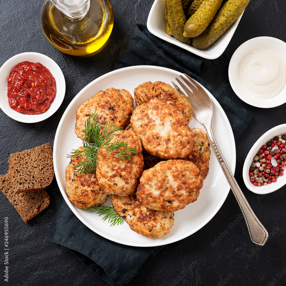 Juicy delicious meat cutlets in a white plate on a black stone table. Top view Juicy delicious meat cutlets in a white plate on a black stone table. Top view