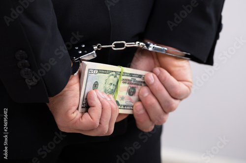 An Arrested Person Holding Dollars Bill