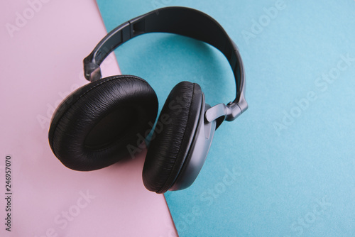 Photo of minimallist black headphones on blue, pink table photo