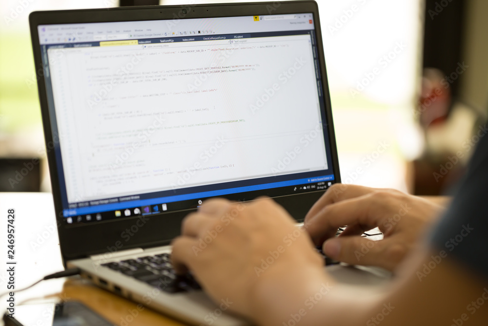 Freelance programmer or developer working at home and typing source code with laptop Freelance programmer or developer working at home and typing source code with laptop
