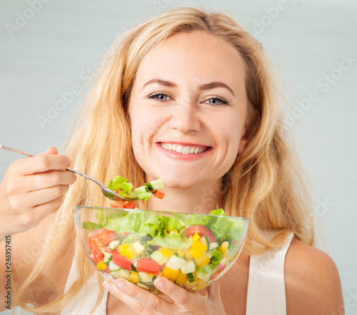 Young woman eating vegetable salad