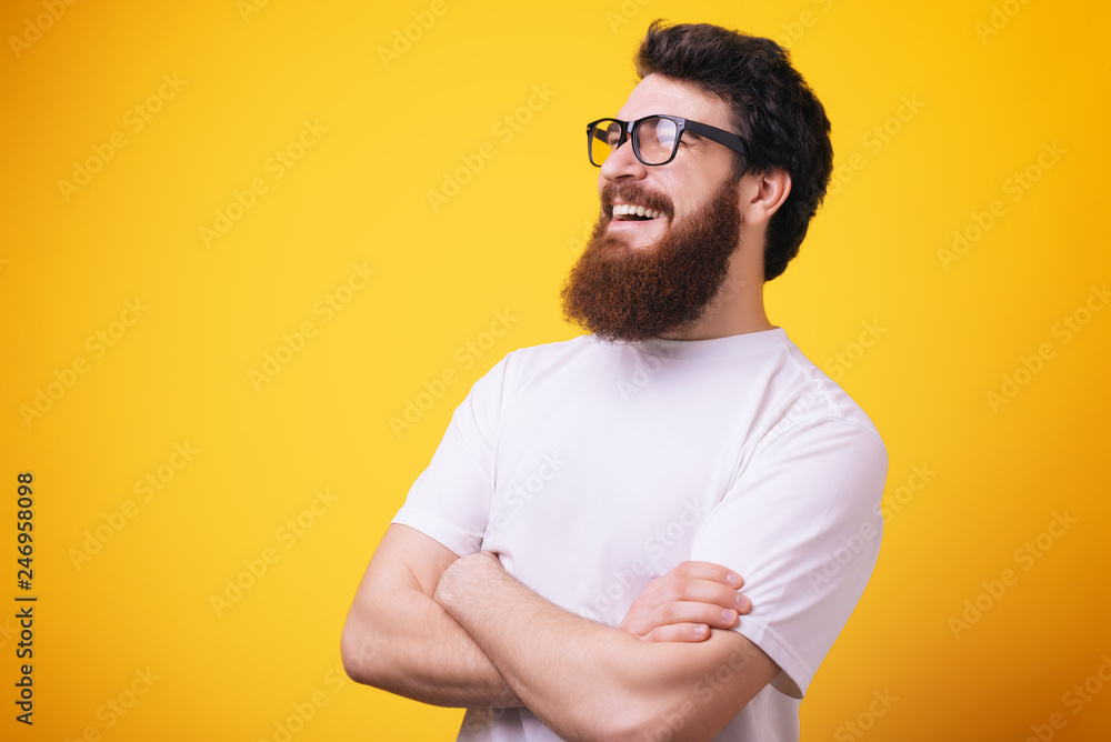 Handsome attractive bearded man laughs at funny story with crosses hands Handsome attractive bearded man laughs at funny story with crosses hands