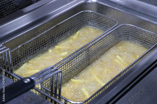 potato chicps frying in a deep fryer photo