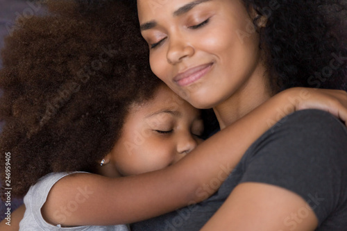 Papier peint Loving single black mother hugs cute daughter feel tenderness connection, happy