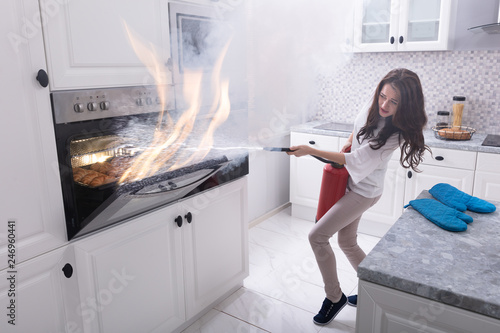 Woman Trying To Stop Fire Coming Out From Oven