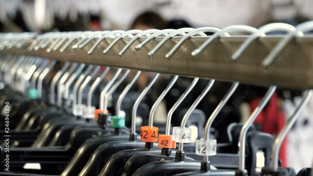 The interior of the clothing store. Close-up shot of rack of clothes. 4K The interior of the clothing store. Close-up shot of rack of clothes. 4K