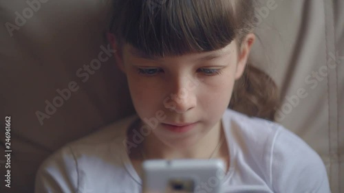 close-up portrait of a Caucasian teenage girl playing on a smartphone online game
 photo