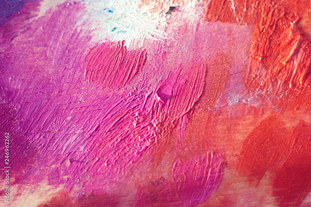 Strokes of red, orange and pink paint on a wooden palette Strokes of red, orange and pink paint on a wooden palette