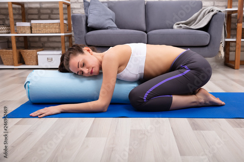 Young Woman Practicing Yoga With Bolster