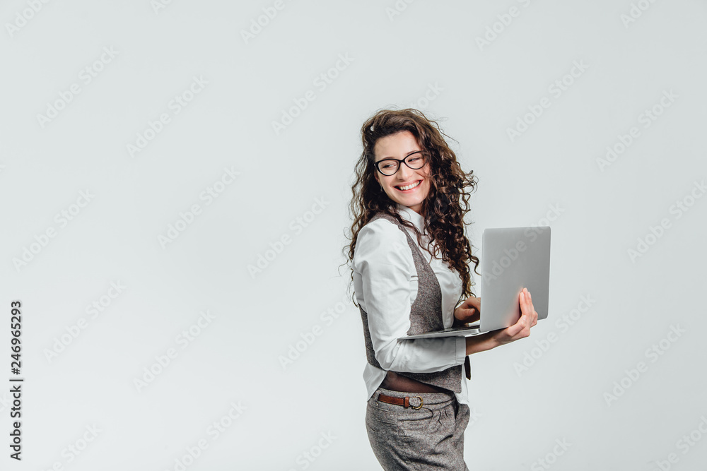 BBeautiful young girl smiles. Works on a laptop in glasses and a white shirt BBeautiful young girl smiles. Works on a laptop in glasses and a white shirt
