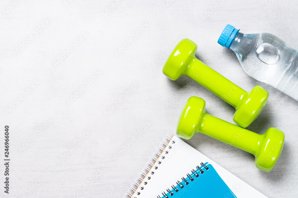 Dumbbells, notepad, water and apple top view. Dumbbells, notepad, water and apple top view.