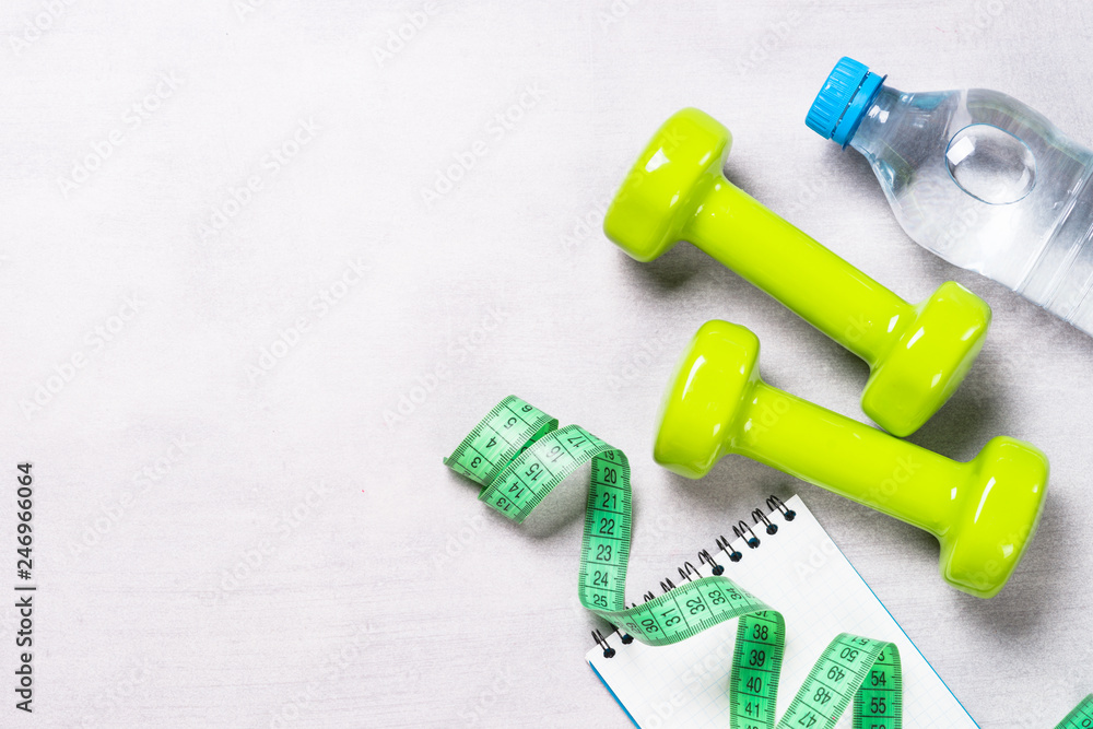 Dumbbells, measuring tape, water and apple top view. Dumbbells, measuring tape, water and apple top view.