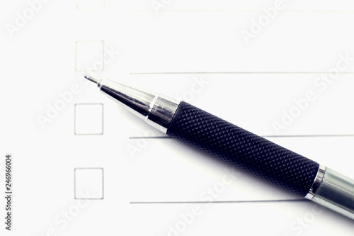 Checklist form with a pen on white paper. Checkbox concept.
