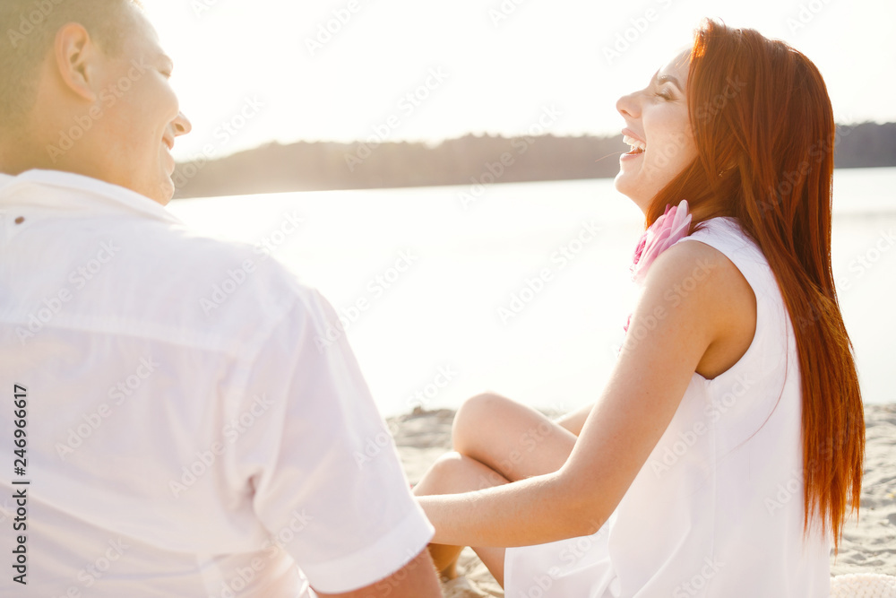 Young couple is holding hands at the beach on a sunny day. Young couple is holding hands at the beach on a sunny day.