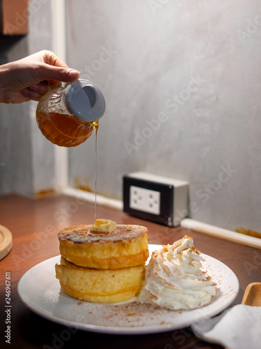 Fluffy Japan souffle pancakes, hotcakes with honey syrup and butter light concrete background copy space