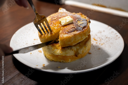 enjoy eating with forkFluffy Japan souffle pancakes, hotcakes with honey syrup and butter light concrete