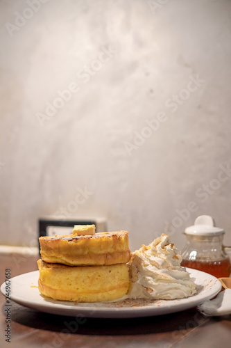 Fluffy Japan souffle pancakes, hotcakes with honey syrup and butter light concrete background copy space