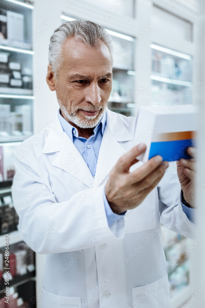 Grey-haired sunburnt Caucasian man in a white coat feeling contented Grey-haired sunburnt Caucasian man in a white coat feeling contented