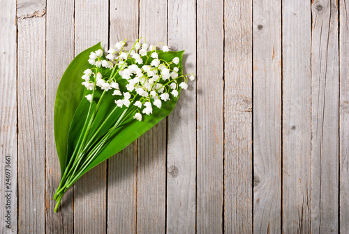 bouquet of lily of the valley on old weathered wooden table background