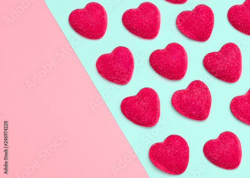 Valentine's day concept Top view Many crimson heart-shaped candies on a two-tone background Photo template with copy space for posters and banners