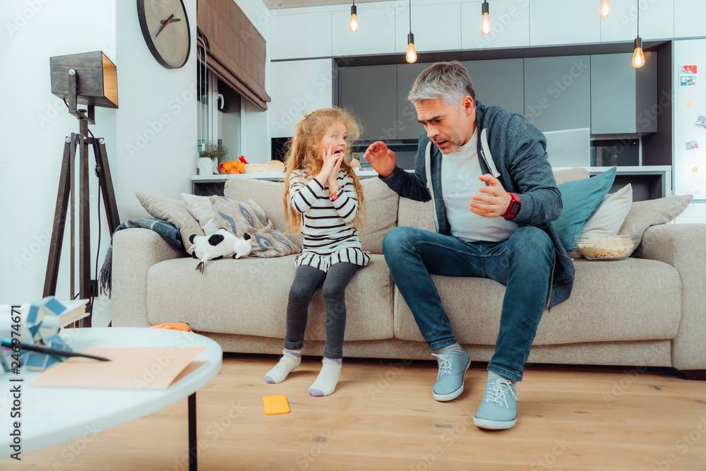 Fototapeta premium Pretty long-haired girl in a dress and her grey-haired father feeling scared