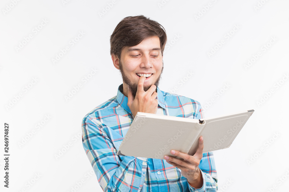 Education, leisure and people concept - young beard man reading a book and smiling Education, leisure and people concept - young beard man reading a book and smiling