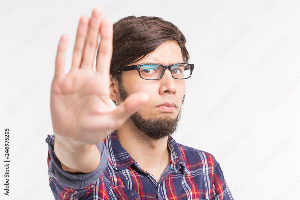 People, expression and gesture concept - young man showing stop gesture on white background People, expression and gesture concept - young man showing stop gesture on white background