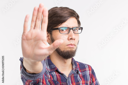 People  expression and gesture concept - young man showing stop gesture on white background