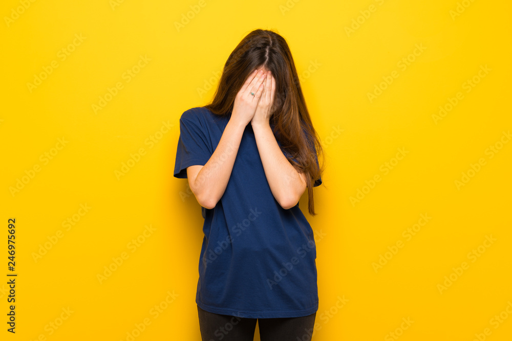 Young woman with glasses over yellow wall with tired and sick expression Young woman with glasses over yellow wall with tired and sick expression