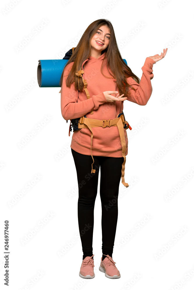 Full-length shot of Hiker girl extending hands to the side for inviting to come on isolated white background Full-length shot of Hiker girl extending hands to the side for inviting to come on isolated white background